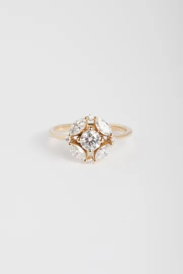 La bague Rina M, en or rose 750‰, sertie d'un diamant central taille brillant et accompagné de diamants taille marquise et brillant.