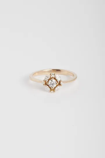 La bague Rina XS, en or rose 750‰, sertie d'un diamant central taille brillant et accompagné de diamants taille marquise et brillant.