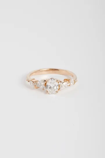 La bague Rania L, ou la passion, en or rose 750‰ sertie d'un diamant central taille ovale et accompagné de diamants taille marquise et brillant.
