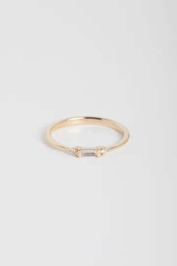 La bague Nessa, en or rose 750‰, sertie d'un diamant taille baguette et accompagné de diamants taille brillant.
