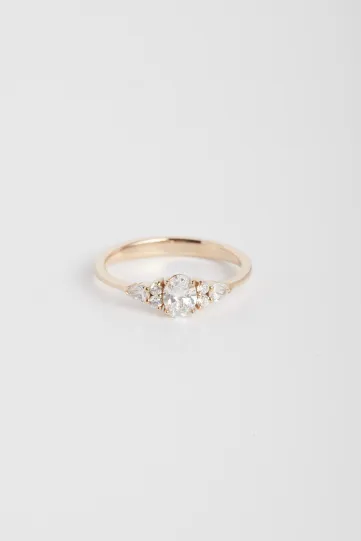 Une bague Julie S en or rose 750‰ sertie d'un diamant ovale et accompagné de diamants taille poire et taille brillant.