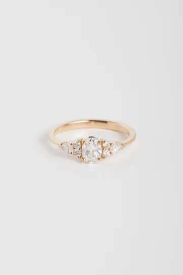 Une bague Julie L en or rose 750‰ sertie d'un diamant ovale et accompagné de diamants taille poire et taille brillant.