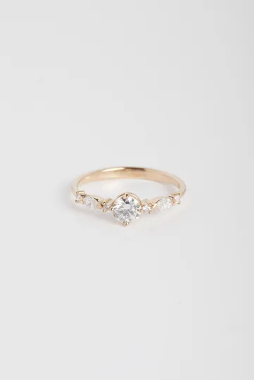 La bague Prune S, en or rose 750‰, sertie d'un diamant central taille brillant et accompagné de diamants taille brillant et marquise.