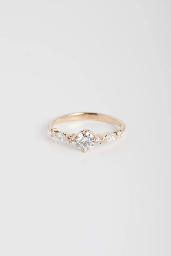 The Prune S ring, in 18k rose gold, set with a brilliant-cut central diamond and accompanied by brilliant and marquise diamonds. The Prune S ring, in 18k rose gold, set with a brilliant-cut central diamond and accompanied by brilliant and marquise diamonds.