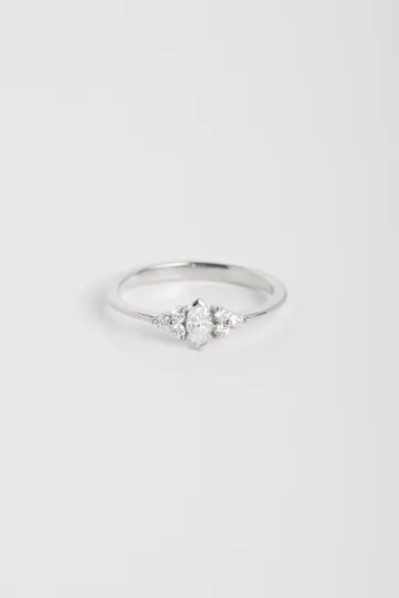 La bague Adeline XS en or blanc 750‰, sertie d'un diamant taille marquise et accompagnée de diamants taille brillant.
