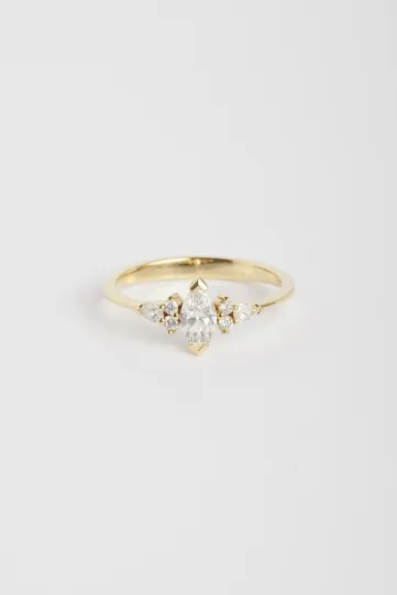 La bague Anne S en or jaune 750‰ sertie d'un diamant central taille marquise et accompagné de diamants taille brillant et poire.