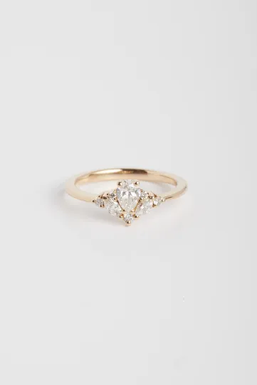 La bague Antoine S en or rose 750‰ sertie d'un diamant central taille poire de 0.30Ct et accompagné de diamants taille marquise et brillant.