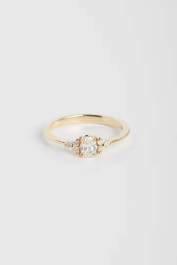 La bague Clara S, en or jaune 750‰ sertie d'un diamant central taille ovale et accompagné de diamants taille brillant.