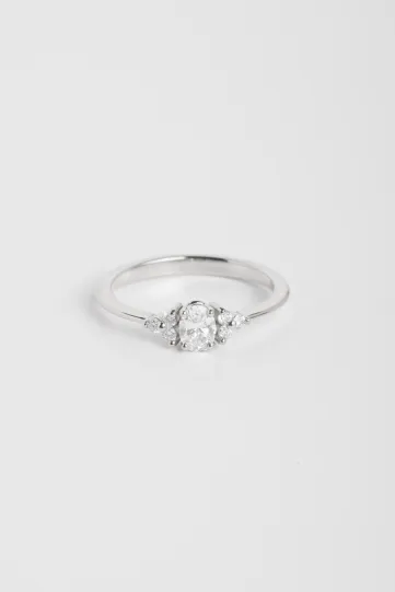 La bague Clara S, en or blanc 750‰ sertie d'un diamant central taille ovale et accompagné de diamants taille brillant.