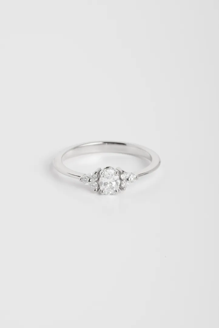 La bague Clara S, en or blanc 750‰ sertie d'un diamant central taille ovale et accompagné de diamants taille brillant. La bague Clara S, en or blanc 750‰ sertie d'un diamant central taille ovale et accompagné de diamants taille brillant.