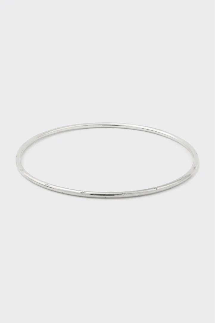 The Douce bracelet in 18k white gold, hand-engraved with star motifs. The Douce bracelet in 18k white gold, hand-engraved with star motifs.