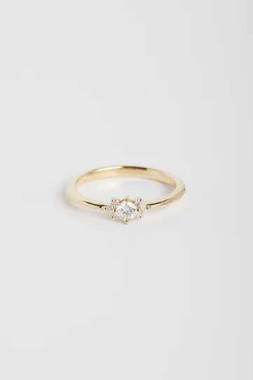 La bague Farah XS, en or jaune 750‰, sertie d'un diamant central taille coussin et accompagné de diamants taille brillant