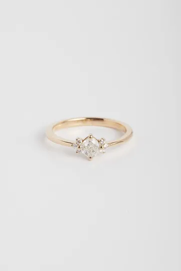 La bague Farah M, en or rose 750‰, sertie d'un diamant central taille coussin et accompagné de diamants taille brillant