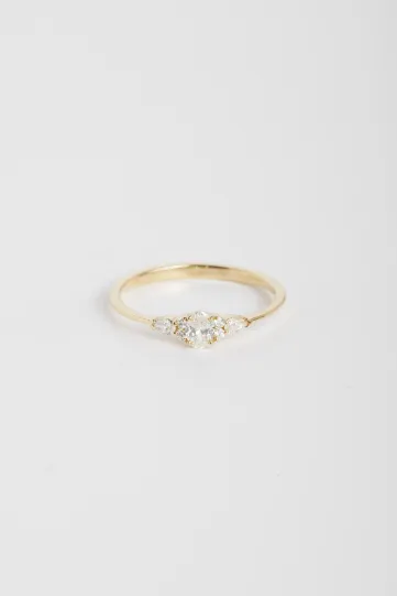 Une bague Julie XS en or jaune 750‰ sertie d'un diamant ovale et accompagné de diamants taille poire et taille brillant.