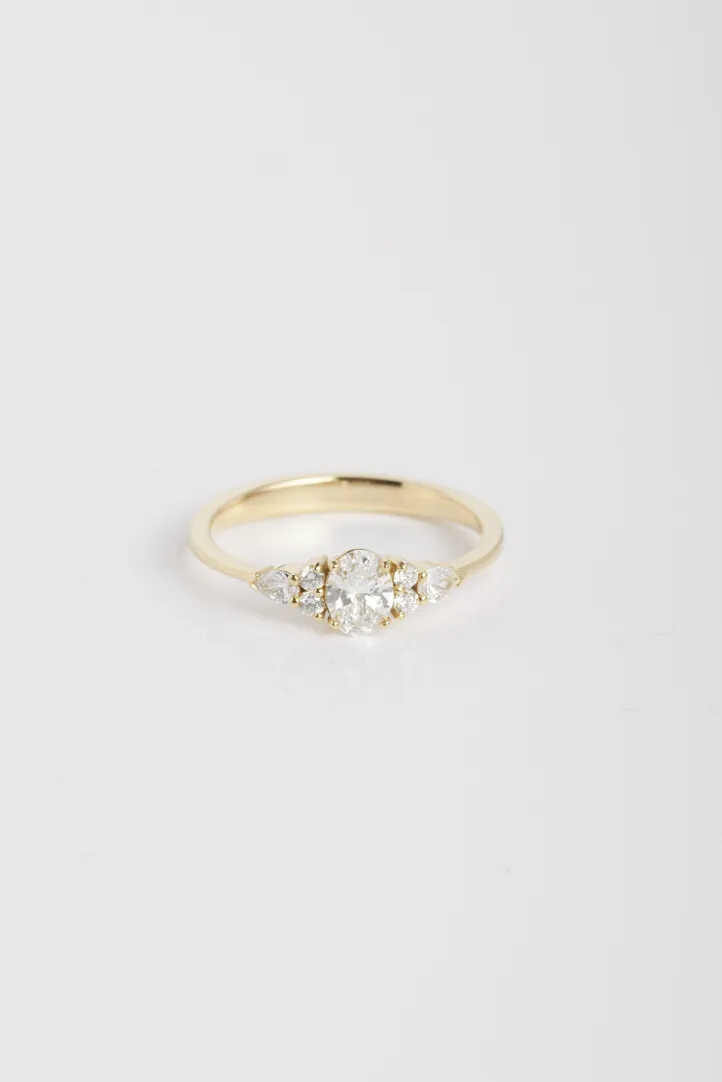 A Julie S ring in 18k yellow gold set with an oval diamond and accompanied by pear-cut and brilliant-cut diamonds. A Julie S ring in 18k yellow gold set with an oval diamond and accompanied by pear-cut and brilliant-cut diamonds.