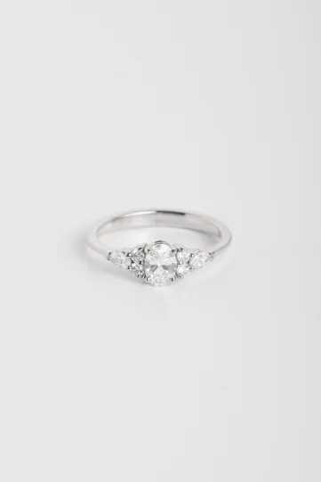 Une bague Julie M en or blanc 750‰ sertie d'un diamant ovale et accompagné de diamants taille poire et taille brillant.