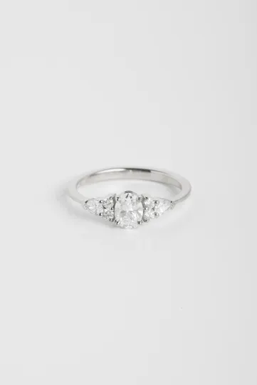 Une bague Julie L en or blanc 750‰ sertie d'un diamant ovale et accompagné de diamants taille poire et taille brillant.