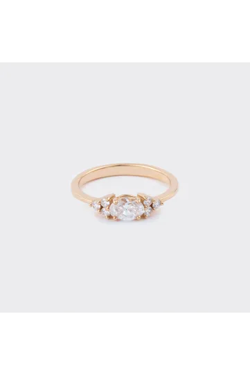 La bague Kenza M en or rose 750‰, sertie d'un diamant taille ovale et accompagné de diamants taille brillant