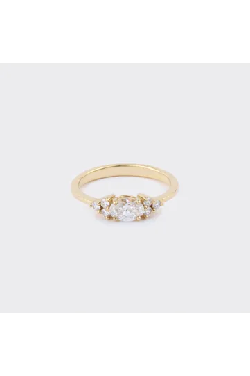 La bague Kenza M en or jaune 750‰, sertie d'un diamant taille ovale et accompagné de diamants taille brillant
