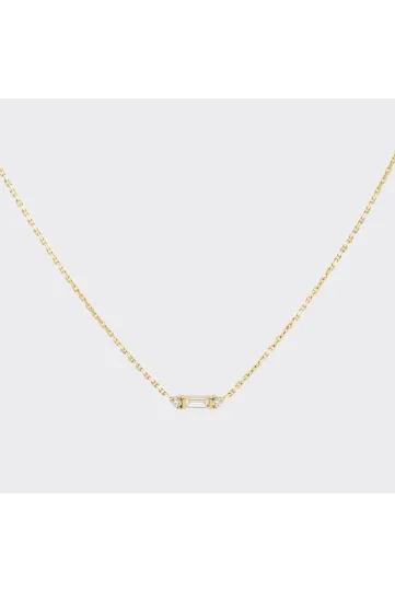 Le collier Nessa en or jaune 750‰ serti d'un diamant taille baguette et accompagné de diamants taille brillant.