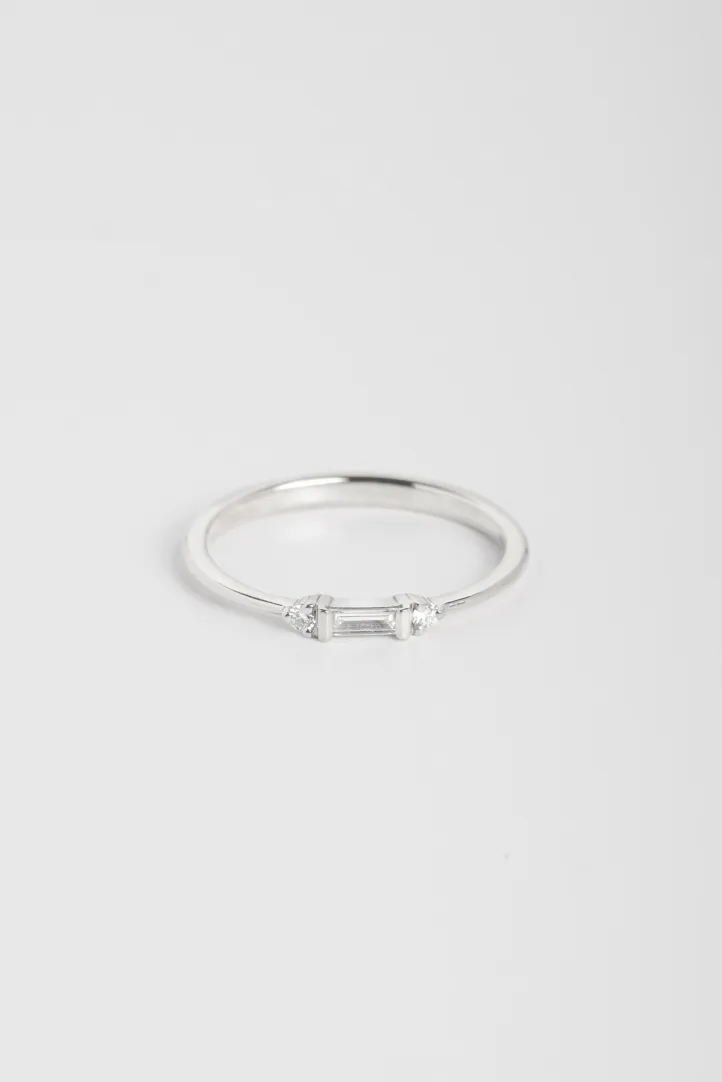 A Sacha XS ring in 18k white gold set with a central round diamond and accompanied by pear-cut diamonds. A Sacha XS ring in 18k white gold set with a central round diamond and accompanied by pear-cut diamonds.