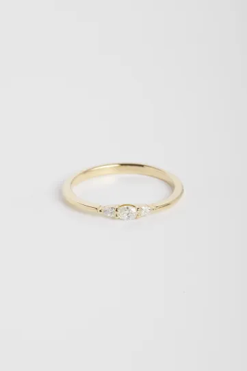 La bague Lou, en or jaune 750‰, sertie d'un diamants taille ovale et accompagné de deux diamants taille poire.