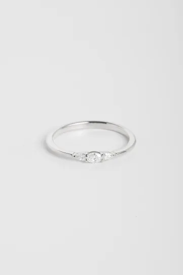 La bague Lou, en or blanc 750‰, sertie d'un diamants taille ovale et accompagné de deux diamants taille poire.