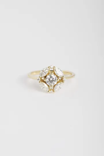La bague Rina M, en or jaune 750‰, sertie d'un diamant central taille brillant et accompagné de diamants taille marquise et brillant.