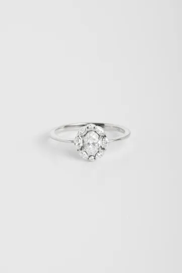 La bague Madeleine en or blanc 750‰ sertie d'un diamant taille ovale et accompagnée de diamants taille marquise.