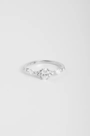 La bague Margot S, en or blanc 750‰, sertie d'un diamant central taille ovale et accompagné de diamants taille brillant et marquise.