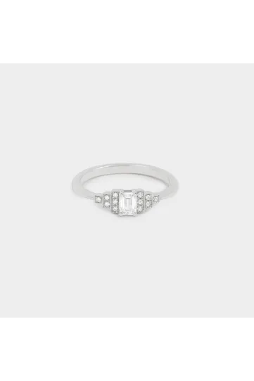 La bague Olympe en or blanc 750‰ sertie d'un diamant taille émeraude et accompagné de diamants taille brillant.