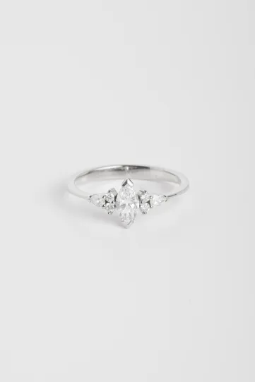 La bague Anne S en or blanc 750‰ sertie d'un diamant central taille marquise et accompagné de diamants taille brillant et poire.