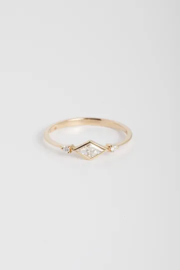 The Xuan ring, in 18k yellow gold, set with a trompe l'oeil triangle-cut diamond and accompanied by brilliant diamonds.