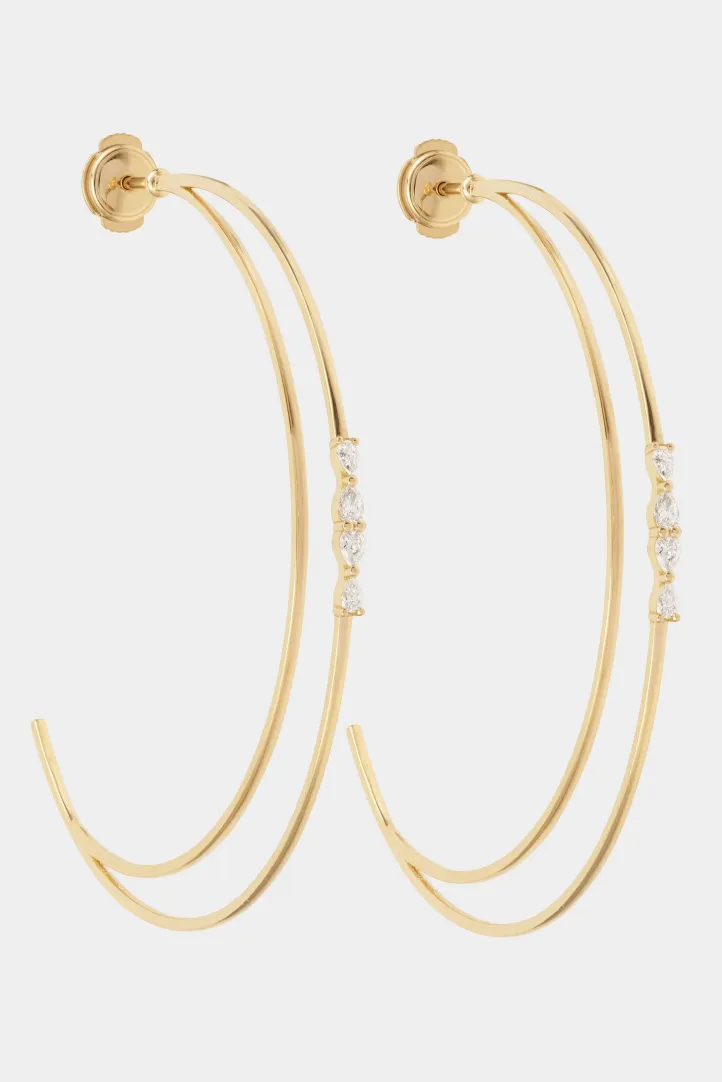 La paire de créoles Ibtissame demi-lune en or 750‰, sertie de diamants taille poire avec un fermoir sécurisé. La paire de créoles Ibtissame demi-lune en or 750‰, sertie de diamants taille poire avec un fermoir sécurisé.