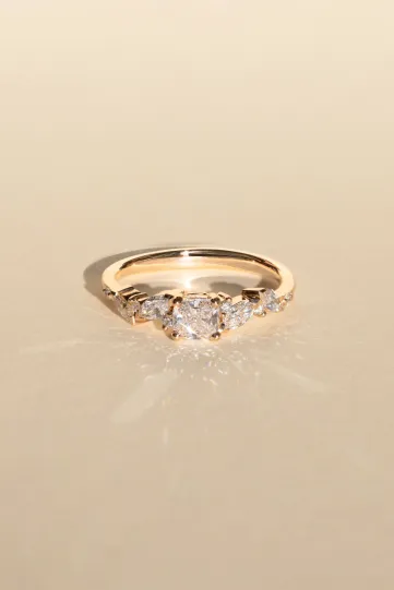 <p>La bague Rania, ou la passion, en or rose 750‰, sertie d'un diamant central taille coussin et accompagné de diamants taille marquise et brillant.</p>