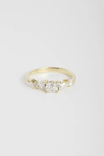 <p>La bague Rania Coussin en or jaune 750‰, sertie d'un diamant central taille coussin et accompagné de diamants taille marquise et brillant.</p>