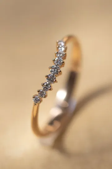 The curved Stella ring in 750‰ rose gold set with brilliant-cut diamonds.