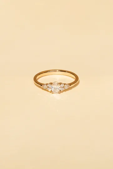 <p>Une bague Julie S en or rose 750‰ sertie d'un diamant ovale et accompagné de diamants taille poire et taille brillant.</p>