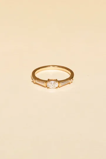 The Marine ring in 750‰ rose gold set with an oval-cut diamond, accompanied by tapered and brilliant-cut diamonds.