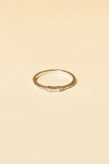 A Sacha XS ring in 18k white gold set with a central round diamond and accompanied by pear-cut diamonds.