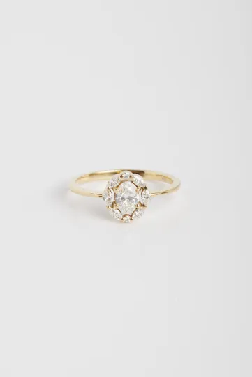 La bague Madeleine en or jaune 750‰, sertie d'un diamant central taille ovale et auréolé de diamants taille marquise et brillant.