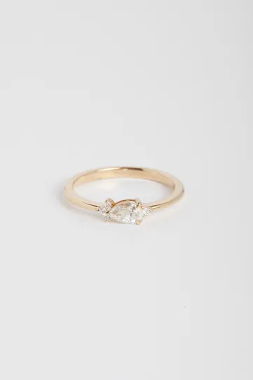 La bague Viridiana S, en or rose 750‰, sertie d'un diamant taille poire et accompagné de diamants taille brillant.